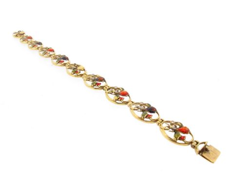 An Art Nouveau gold and enamel bracelet, each oval shaped panel is mounted with a flower head with enamel decoration and a sm