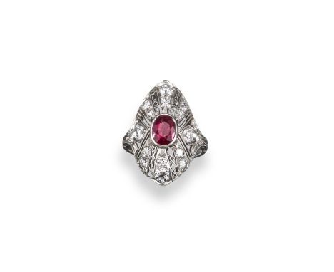 A ruby and diamond cluster ring, the centre oval-shaped ruby is set with graduated round brilliant-cut diamonds to the filigr