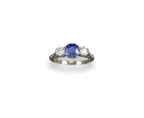 A sapphire and diamond three-stone ring, the circular-cut sapphire set with two circular-cut diamonds in platinum and white g