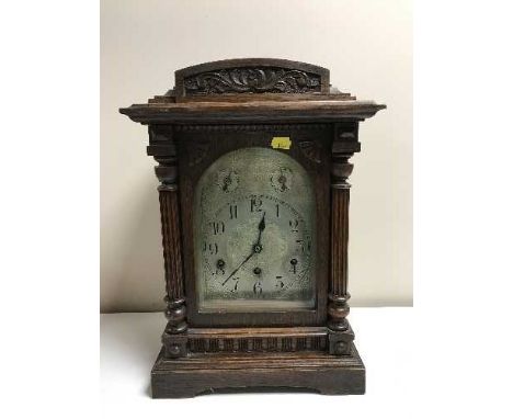 A carved oak chiming bracket clock with silvered dial 