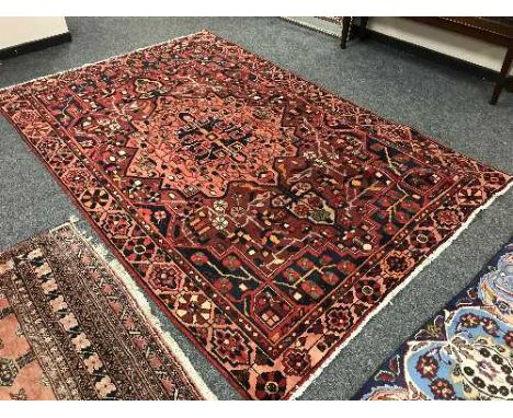 A Persian Heriz carpet on red ground 300 cm x 190 cm