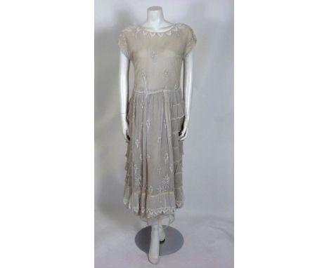 An Edwardian white tulle tea dress,with scallop lace, 'V' shaped neckline, bodice and skirt, decorated with floral embroidere