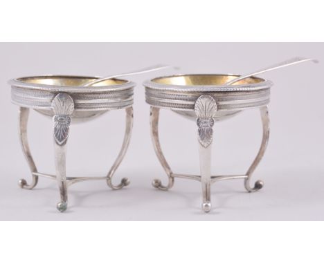 A pair of French Empire style white metal brazier-shaped salts, probably French, shallow near hemispherical gilt bowls, scrol