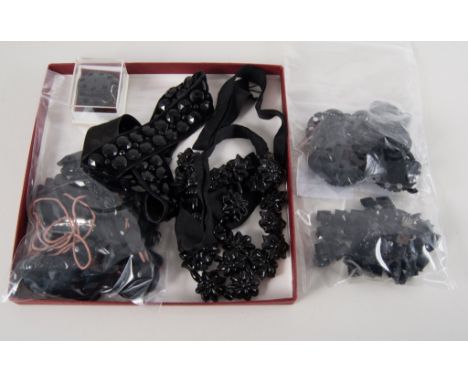 A collection of faceted jet beads, various carved design links, a velvet collar with faceted button studs,