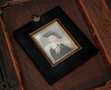 An early 19th century portrait miniature of a young man with a kite, watercolour on ivory, wearing a dark blue tunic and whit