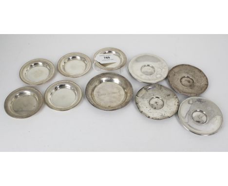 A set of five Arabic silver miniature plates, with engraved edges and beaded rims, 2¾in. (7cm.) diameter; together with two f