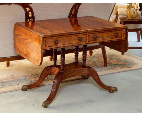 A George IV cross banded mahogany sofa table, the rosewood cross banded top over an ebony inlaid frieze with two flush mounte