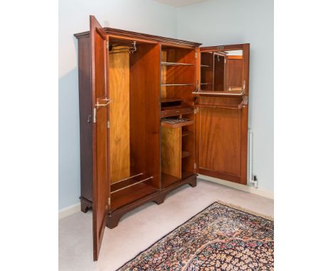 An early 20th century mahogany 'Compactom' wardrobe, the shallow cornice over two panelled doors enclosing a fitted interior,