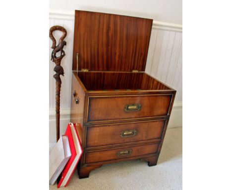 A mahogany drinks cabinet in the form of a miniature George III chest of three drawers, the top lifting to reveal the bottle 