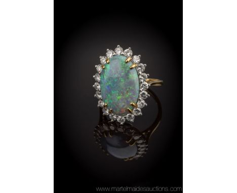 A fine 18ct gold, black opal and diamond cluster ring, hallmarked London 1974, the large, oval cabochon black opal, approx. 1