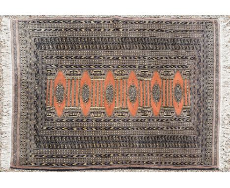 A Turkoman rug, late 20th century, with single row of six octagonal medallions on a pale red ladder ground, within multiple c