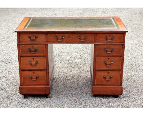 A late Victorian small walnut veneered pedestal desk, the cross banded top with tooled green leather and three drawers, on tw