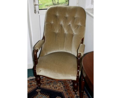 A Victorian walnut framed button back arm chair, the half padded scroll arms and serpentine seat raised on turned inverted ba