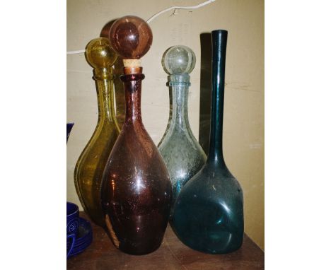 Three large Spanish coloured soda glass decanters, with globe stoppers, 18½ to 19½in. (47 to 49cm.) high, together with a lar