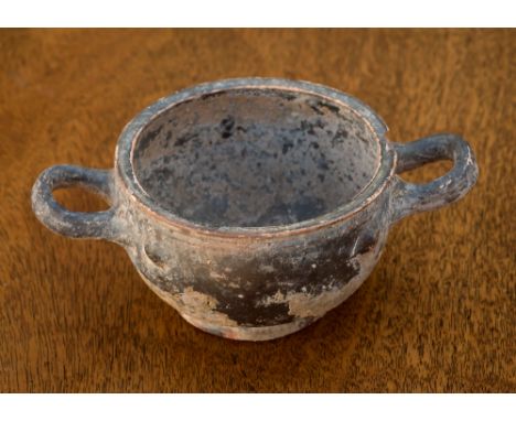 A Greek Hellenistic Skyphos, black attic glaze beneath a covering of encrustation, twin lightly upturned horizontal loop hand