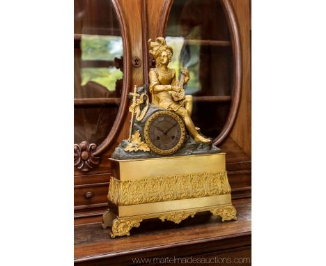 A late 19th century French gilt metal figural mantel clock, modelled as a dandy musician seated upon rockwork, his sword at h