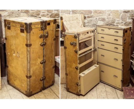 A Finnigans vellum fitted wardrobe cabin trunk, c.1910, opening to reveal one side of graduated drawers and the other with ad