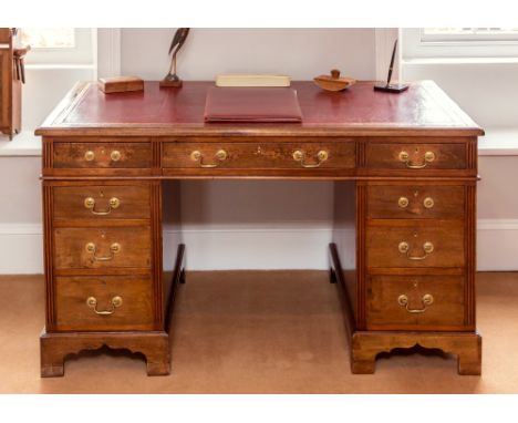 A late Victorian mahogany pedestal desk by Maple & Co., the red leather lined top with caddy moulded edge over a long central