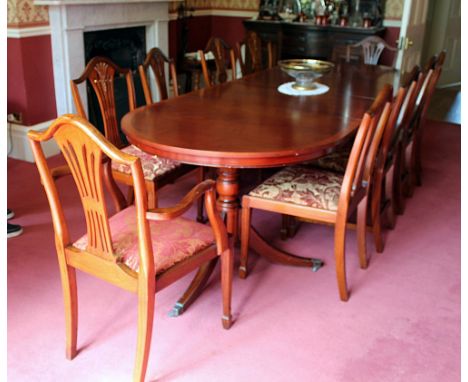 A two pillar D-end yew wood veneered dining table, in George III style, on turned column supports and tripod bases with two s