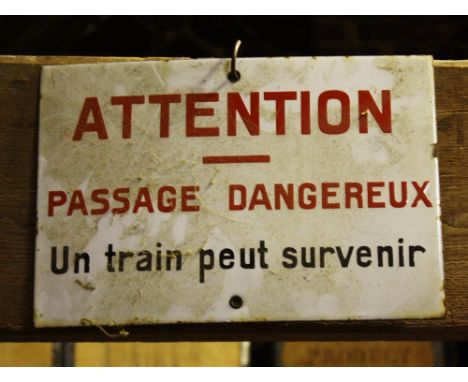 A French enamel train warning sign, 1920s, stating "Attention - Passage Dangereux - un train peut survenir", 12 x 8¼in. (30.5