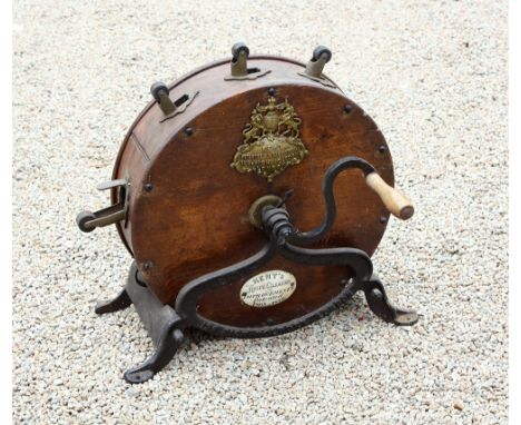 A Victorian circular oak knife polisher, with open ironwork base and S shaped handle, the knife sockets with brass mounts and