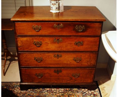 A George III mahogany straight front chest of drawers, the caddy moulded oak top over four long graduated drawers, the sides 