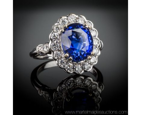 A fine antique style 18ct white gold, sapphire and diamond cluster ring, the 4.43 carat oval cut sapphire of fine quality and