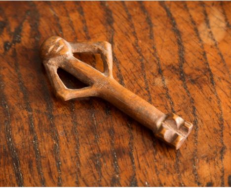 A 16th / 17th century treen carved boxwood figural pipe tamper, the naively carved stick-figure with arms raised to back of h