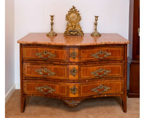 An early 19th century French serpentine fronted commode, of two short over two long drawers, the Alba Rosa marble top over an