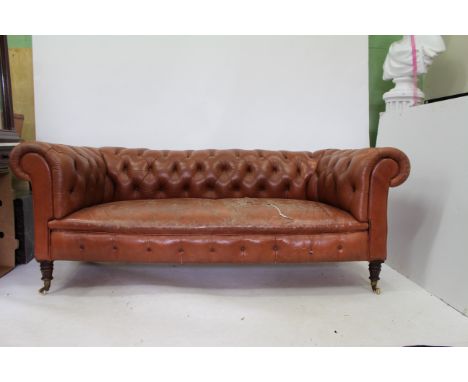 A VICTORIAN BROWN LEATHER BUTTON UPHOLSTERED CHESTERFIELD SOFA standing on turned tapering legs, approximately 190cm wide x 7