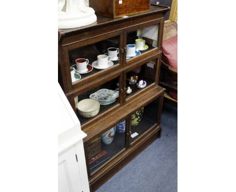 A THREE TIERED OAK GLAZE FRONTED BOOKCASE with brass finial handles