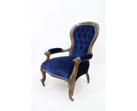 A VICTORIAN WALNUT OPEN ARMCHAIR with button upholstered spoon back with carved crest, blue Draylon upholstered back arms and