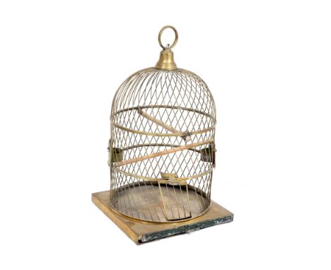 A LATE 19TH / EARLY 20TH CENTURY BRASS PARROT CAGE, of spiralled wire form, a brass bell finial, loop handle and a square bas