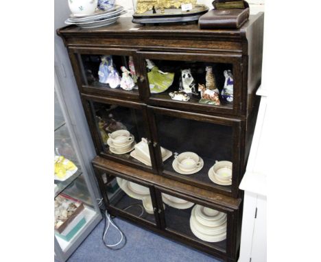 A THREE TIERED OAK GLAZE FRONTED BOOKCASE with brass finial handles