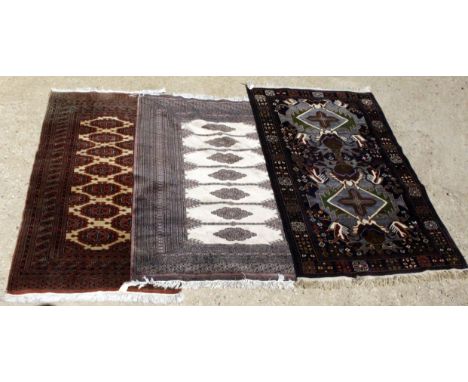 A 20TH CENTURY REPRODUCTION RUG on blue ground with geometric patterns, fringed edges, 204cm x 114cm together with two 20th c