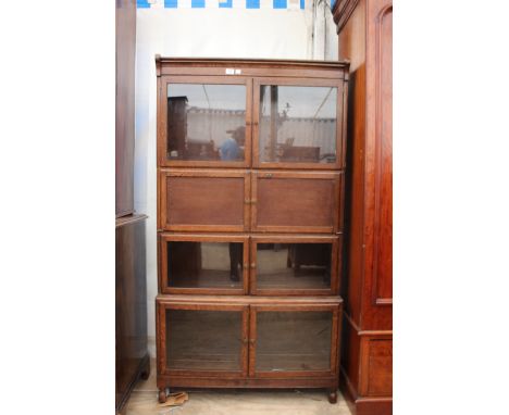 AN EARLY 20TH CENTURY OAK GLAZED OPEN SHELF BOOKCASE consisting of four tiers