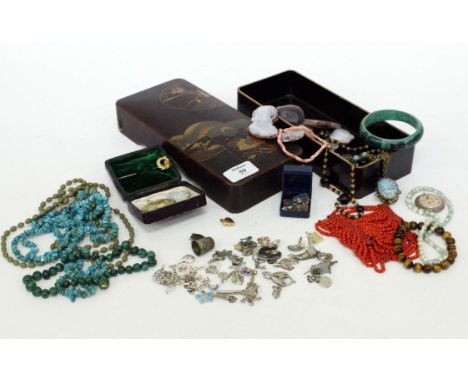 A 20TH CENTURY LACQUERED BOX and contents therein including jade and tigers eye bracelet, a selection of silver charms and a 