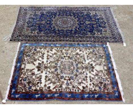 TWO 20TH CENTURY CARPET RUGS, one with a blue border decoration and one with a blue and ivory decoration, each with fringed e