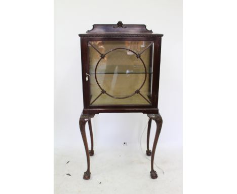 AN EDWARDIAN MAHOGANY SMALL DISPLAY CABINET with a glazed door with central circular decoration enclosing a glass shelf withi