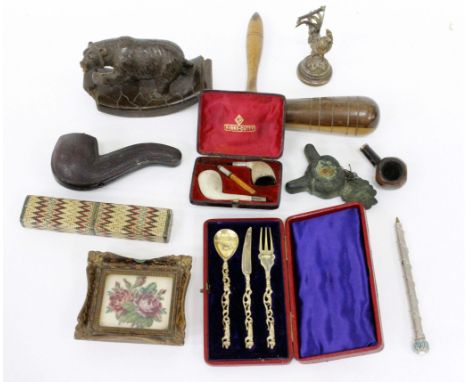 A CASED UNMARKED METAL CHRISTENING SET, a miniature rose tapestry, a black forest carved desk blotter, miscellaneous pipes, p