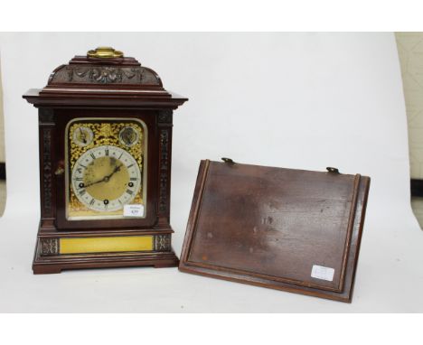 AN EARLY 20TH CENTURY MAHOGANY CASED TABLE OR BRACKET CLOCK in the Georgian style with brass hinged carrying handle, carved d