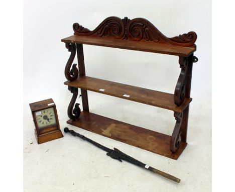 A THREE TIER MAHOGANY WALL SHELF with scrolling supports, 84cm wide; an Edwardian mahogany cased mantle clock and a tribal wa