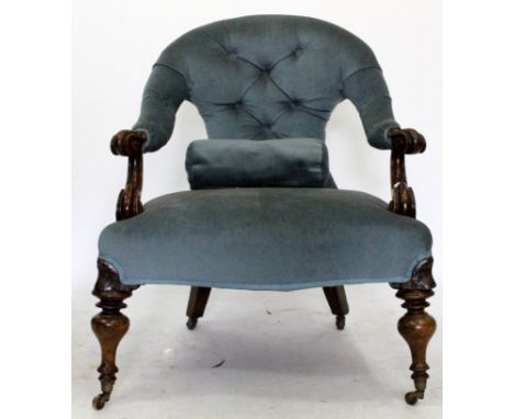 A MAHOGANY CARVED LADIES CHAIR with blue velour and button upholstery on ring turned legs and casters 
