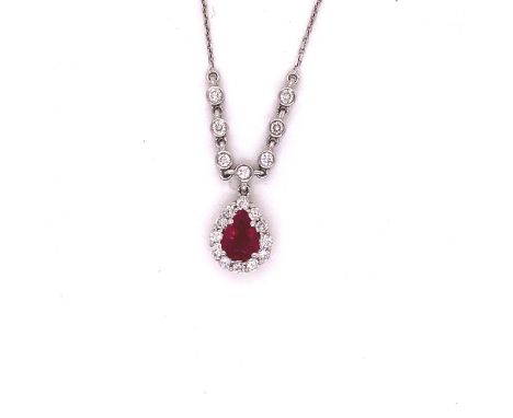 A 14ct WHITE GOLD RUBY AND DIAMOND PENDANT. THE TEARDROP RUBY CLAW SET WITH  A CLUSTER OF BRILLIANT CUT DIAMONDS ARTICULATED 