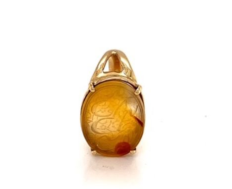 AN ISLAMIC ENGRAVED INTAGLIO HARDSTONE SEAL RING IN A FOUR CLAW SETTING ON A YELLOW GOLD SHANK.THE INTAGLIO FINELY ENGRAVED W