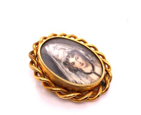 AN ANTIQUE GOLD OVAL BROOCH WITH ROPE EDGE BORDER, CENTRED WITH A ROTATING PANEL OF A PAINTED PORTRAIT MINIATURE OF A YOUNG L