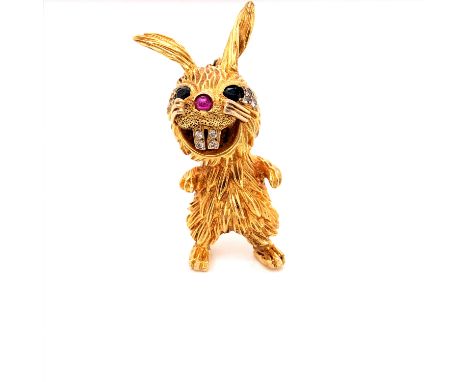 A KUTCHINSKY 18ct GOLD SAPPHIRE DIAMOND AND RUBY BROOCH IN THE FORM OF A RABBIT WITH SAPPHIRE EYES, A RUBY TIP NOSE, AND DIAM