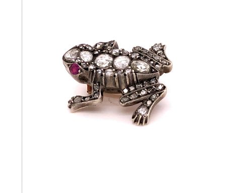 A DIAMOND AND RUBY FROG BROOCH, OLD CUT DIAMONDS ADORN THE BODY COMPLETED WITH RUBY SET EYES. LENGTH 2.6cms, WEIGHT 10.6grms.