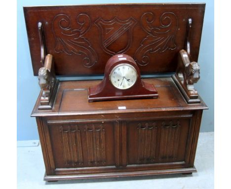 Carved oak Monks bench by L.Marcus Ltd. of London, with lion supports and a mahogany cased mantel clock 
