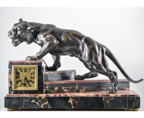 Continental, an Art Deco mantel clock, circa 1925, with large patinated spelter prowling tiger, on an asymmetrical stepped ma